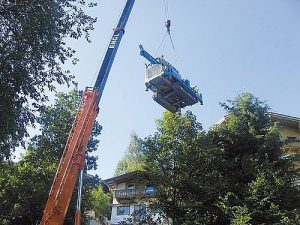 Bohrlafette wird von Telekran über ein Haus gehoben